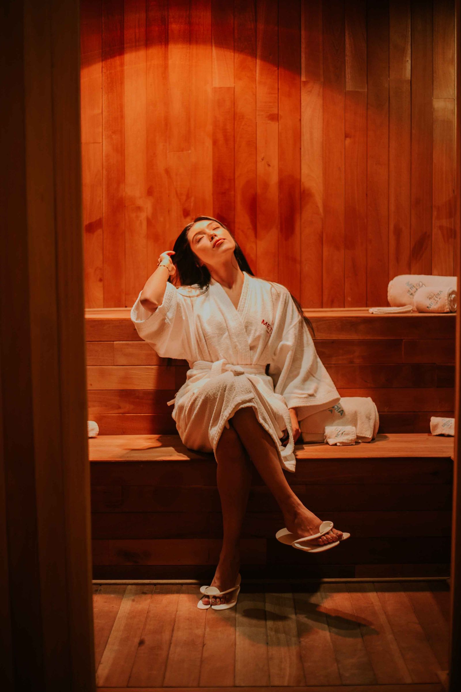 Guest resting in a robe in the cedar sauna