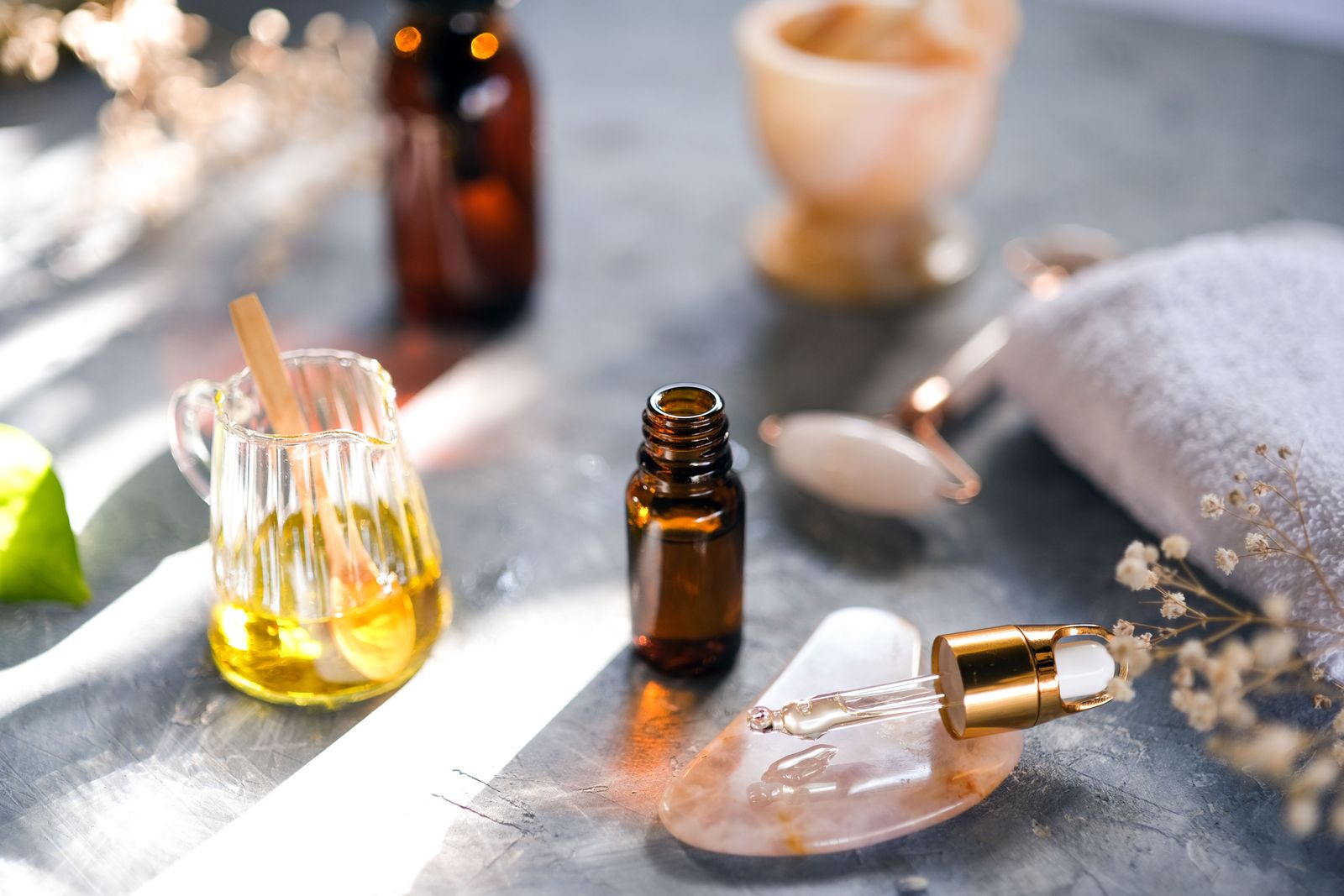 Small bottles of botanical oils and serums on a stone tray